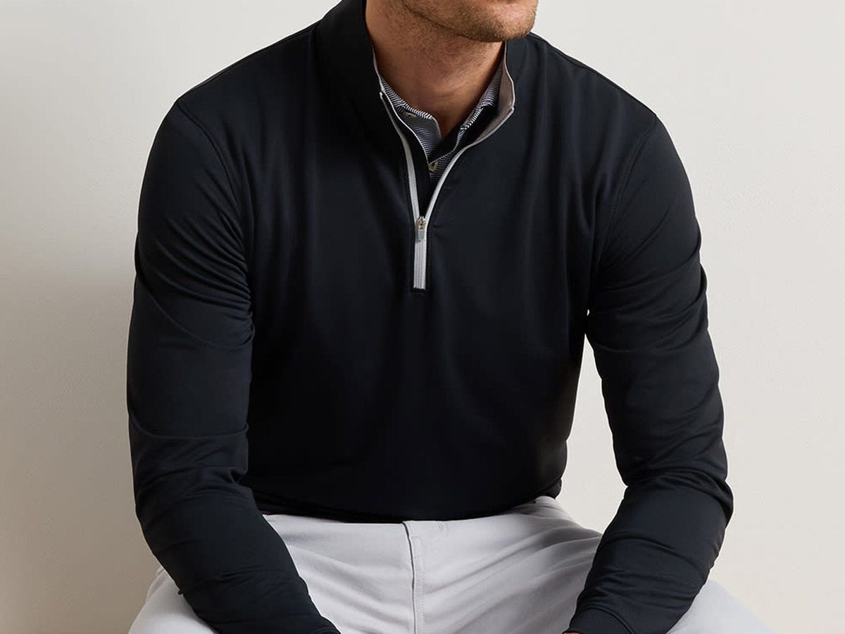 A model wearing a black quarter-zip pullover