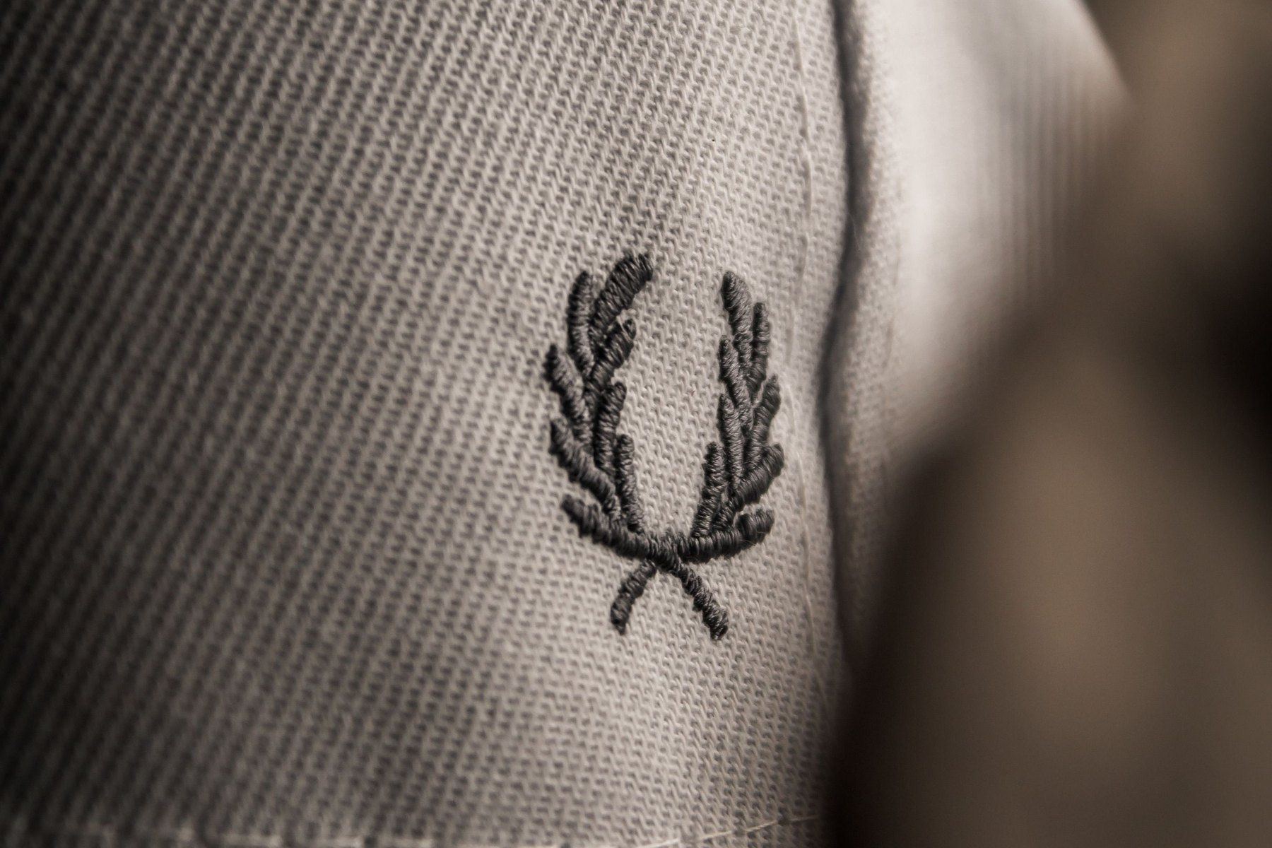 A laurel wreath embroidered on a cream knit